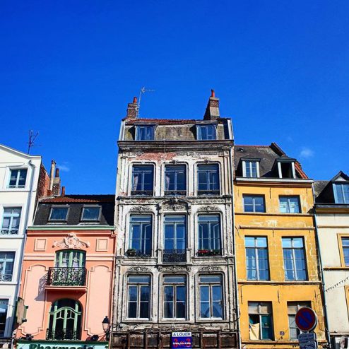 Beautiful architectural buildings in Lille, France, yellow and pink buildings, blue sky