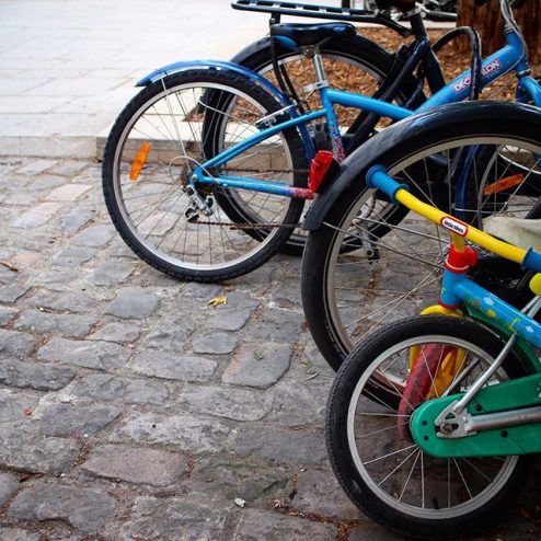 paris school parking lot, rows of bicycle wheels on brick bike rack, images of paris
