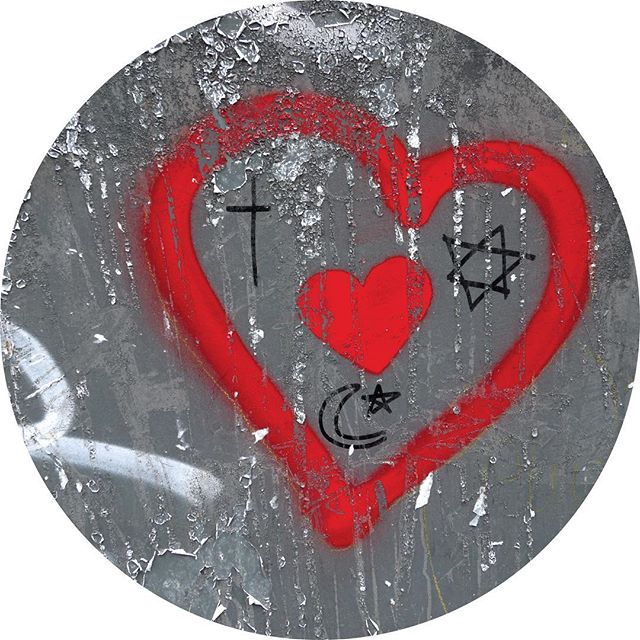 Coexist graffiti of religious symbols encased in a heart